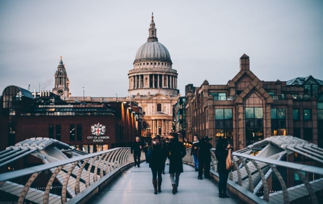 People walking over a bridge in london.